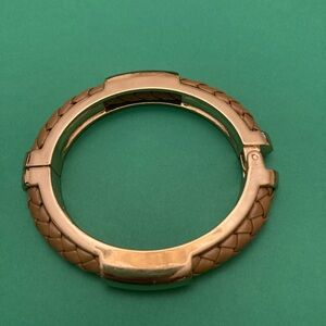 Gold Tone hinged cuff bracelet with braided tan leather inlay.